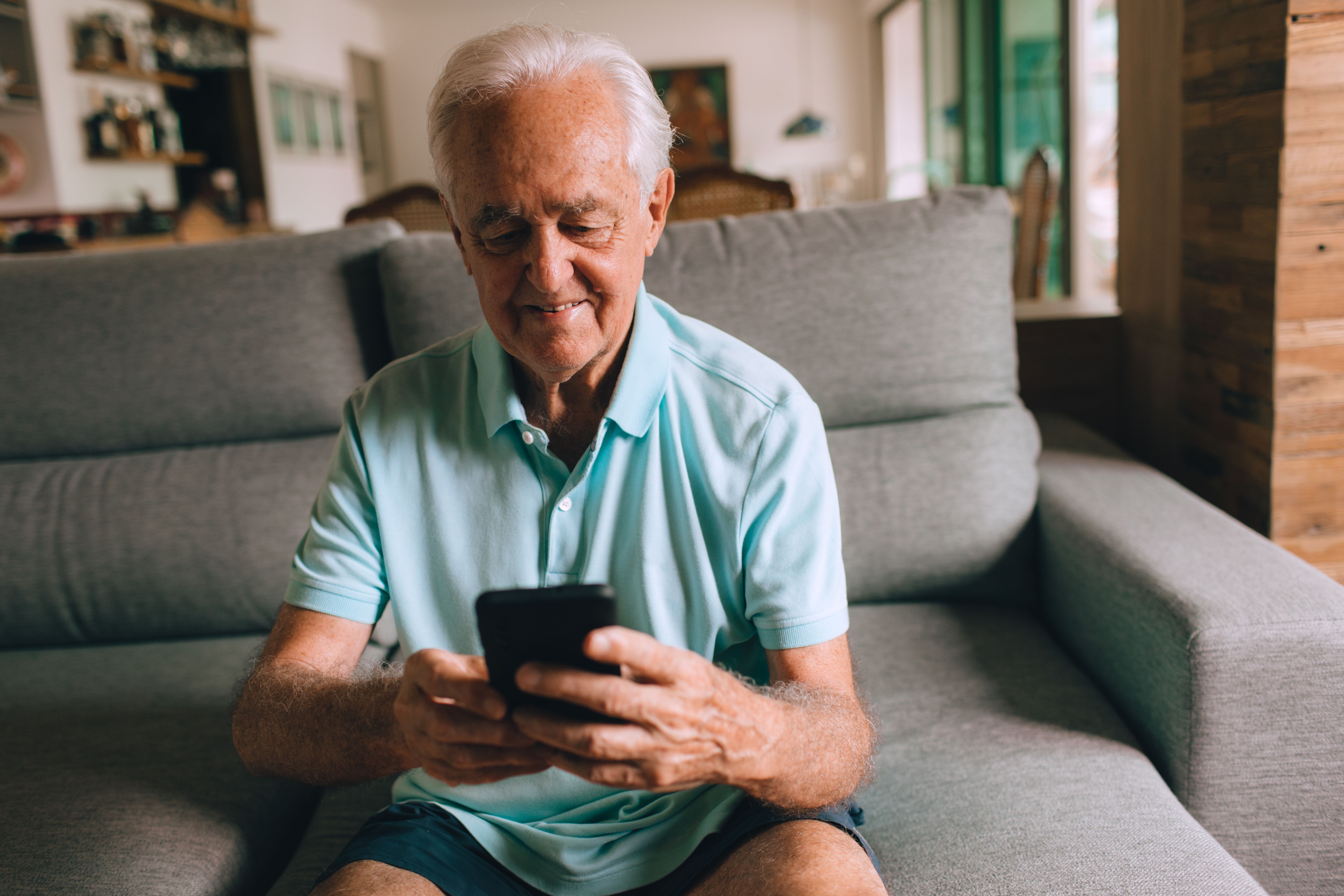Idoso sorrindo enquanto consulta o resultado de exames no celular